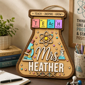 A decorative wooden flask-shaped wall sign for a science teacher, customized with Mrs. Heather on a desk.