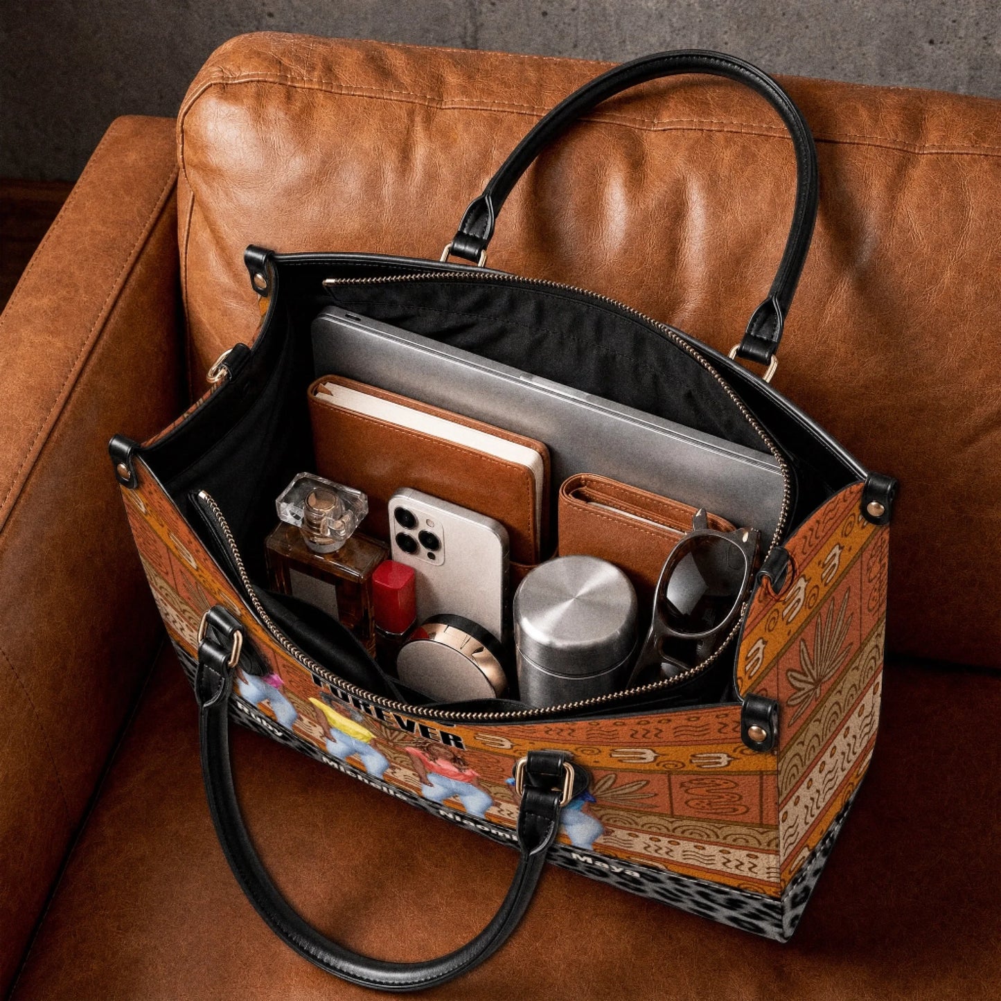 Interior view of a personalized Sistas Forever handbag filled with a laptop, journal, phone, and daily accessories.