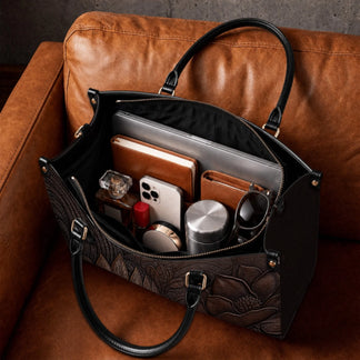 Inside view of a spacious brown embossed leather tote bag organized with a laptop book phone and accessories.
