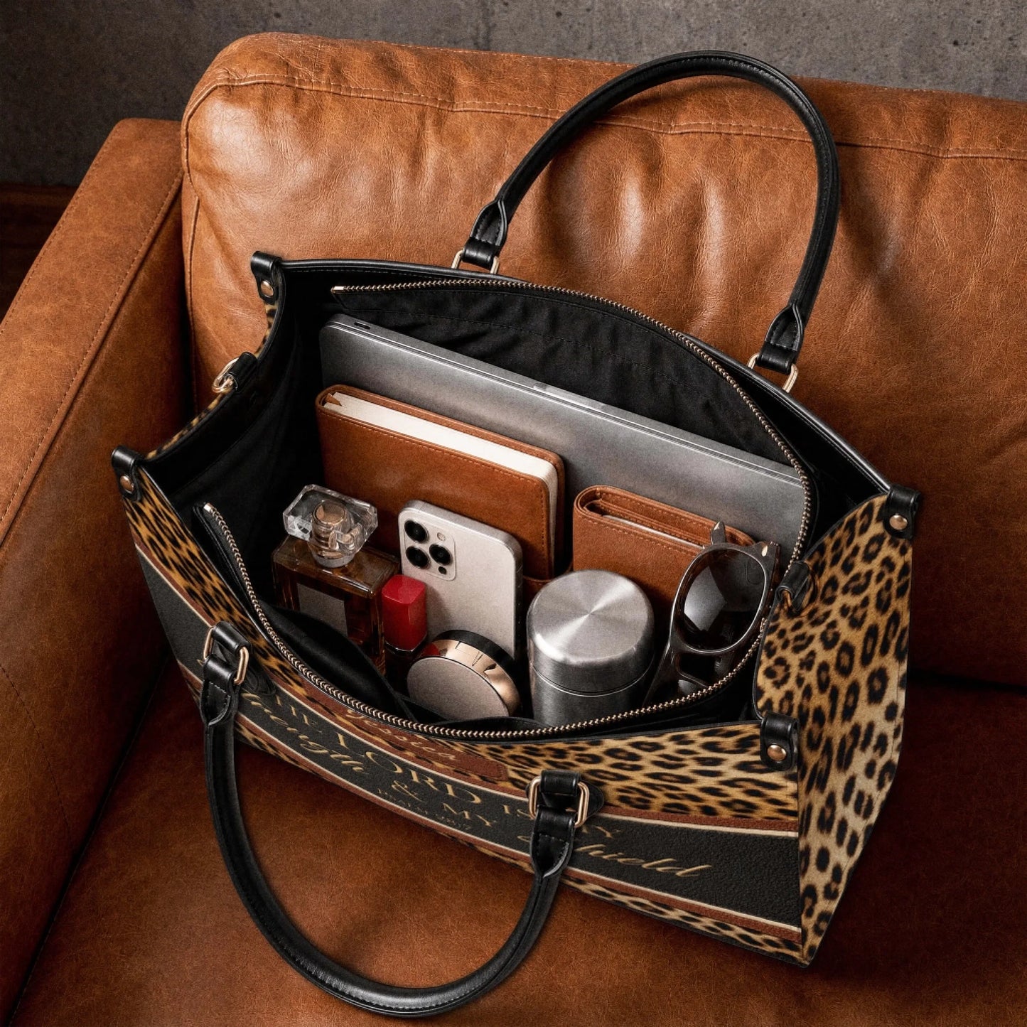 Interior view of a personalized leopard print tote bag organized with a laptop notebook wallet and everyday essentials.