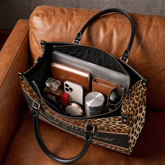 Interior view of a personalized leopard print tote bag organized with a laptop notebook wallet and everyday essentials.