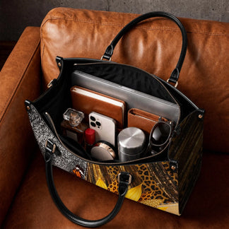 Interior view of a spacious personalized sunflower tote bag filled with everyday items like a laptop, phone, and wallet.