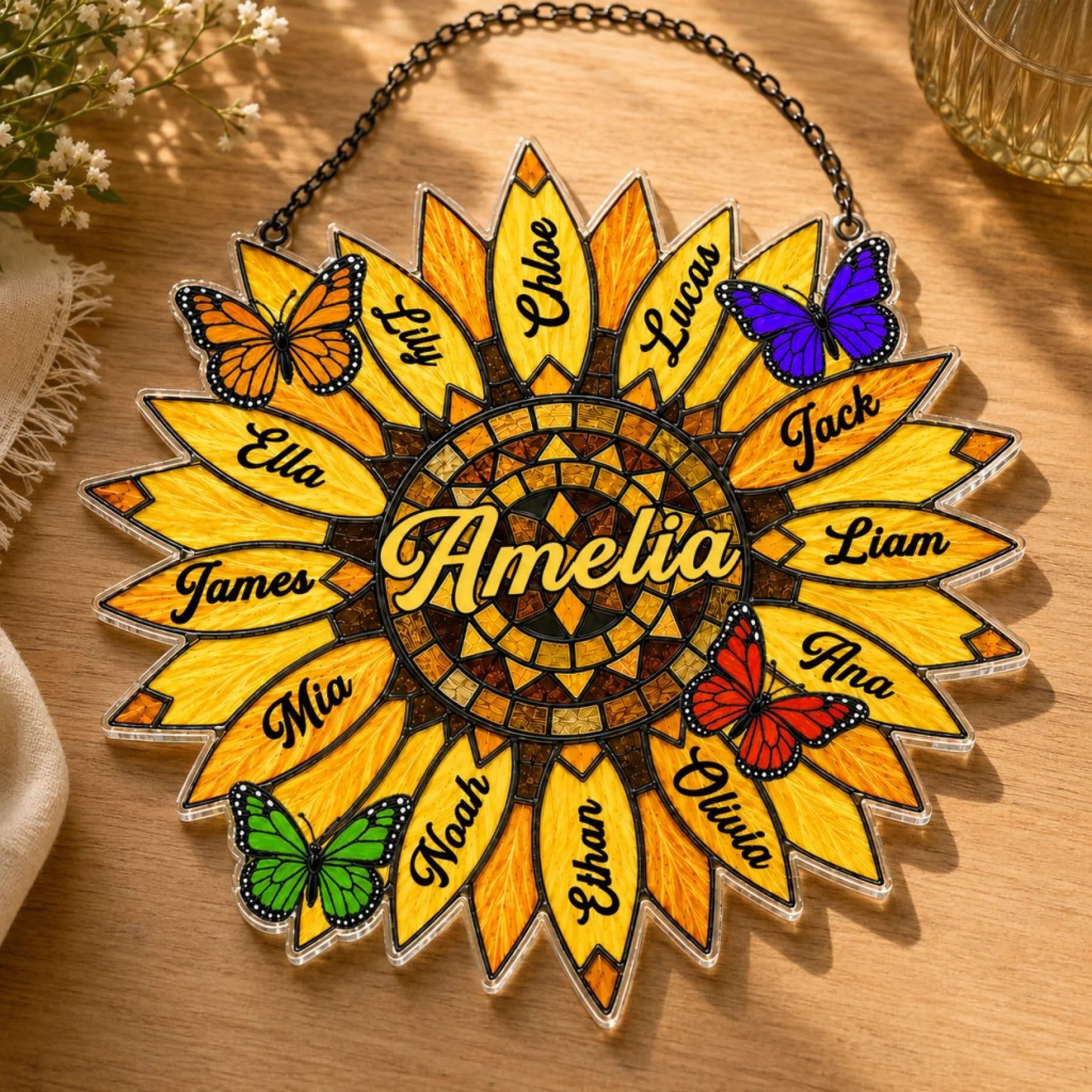 Decorative sunflower-shaped plaque with names and butterflies on a wooden surface.
