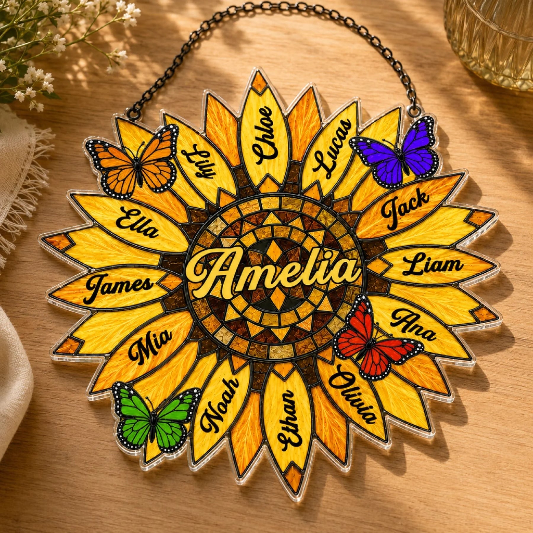 Decorative sunflower-shaped plaque with names and butterflies on a wooden surface.