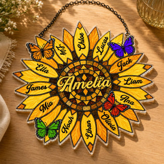 Decorative sunflower-shaped plaque with names and butterflies on a wooden surface.
