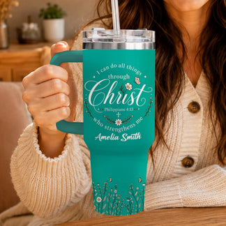 Teal stainless steel tumbler held by a person, featuring religious scripture, floral accents, and a personalized name.