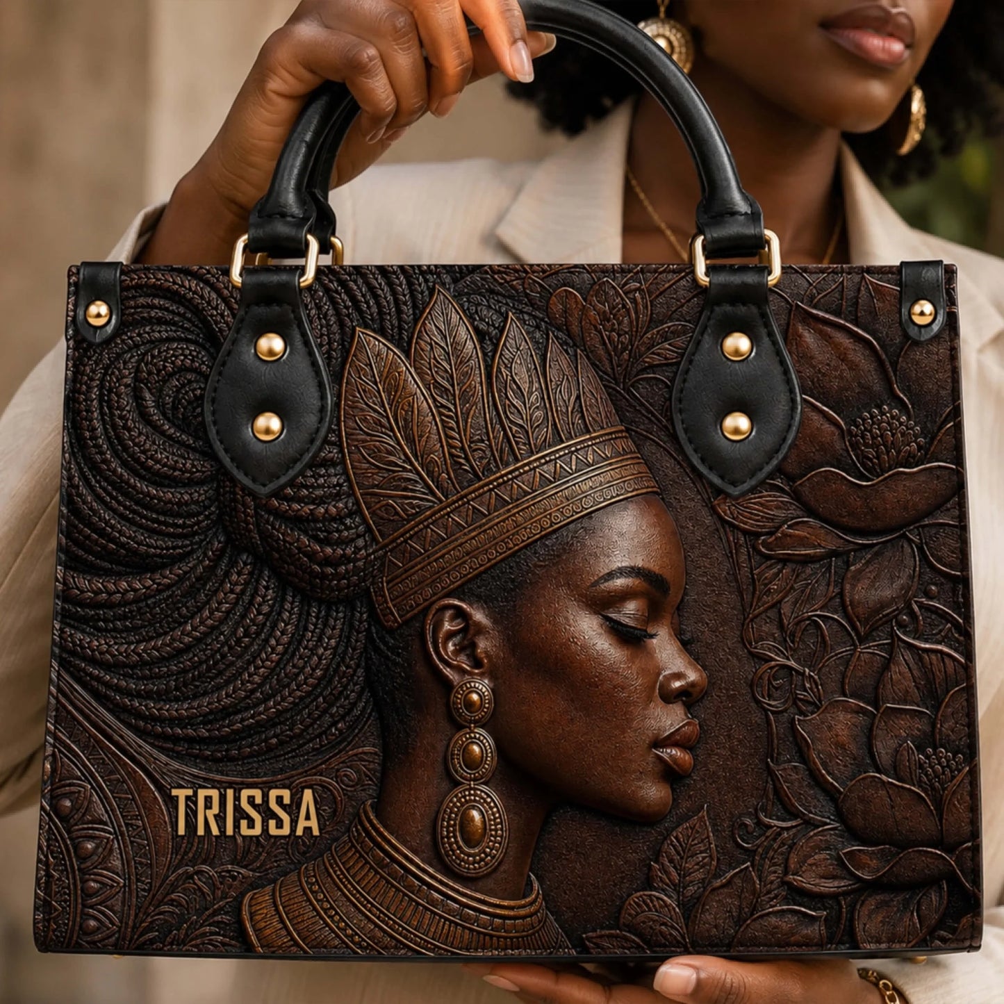 A woman holding a designer leather handbag featuring a detailed embossed portrait of a woman with headpiece.