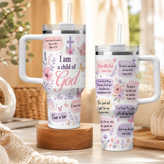 Set of two white tumblers with handles featuring floral designs, butterflies, and Bible verses, displayed on a wooden stand.