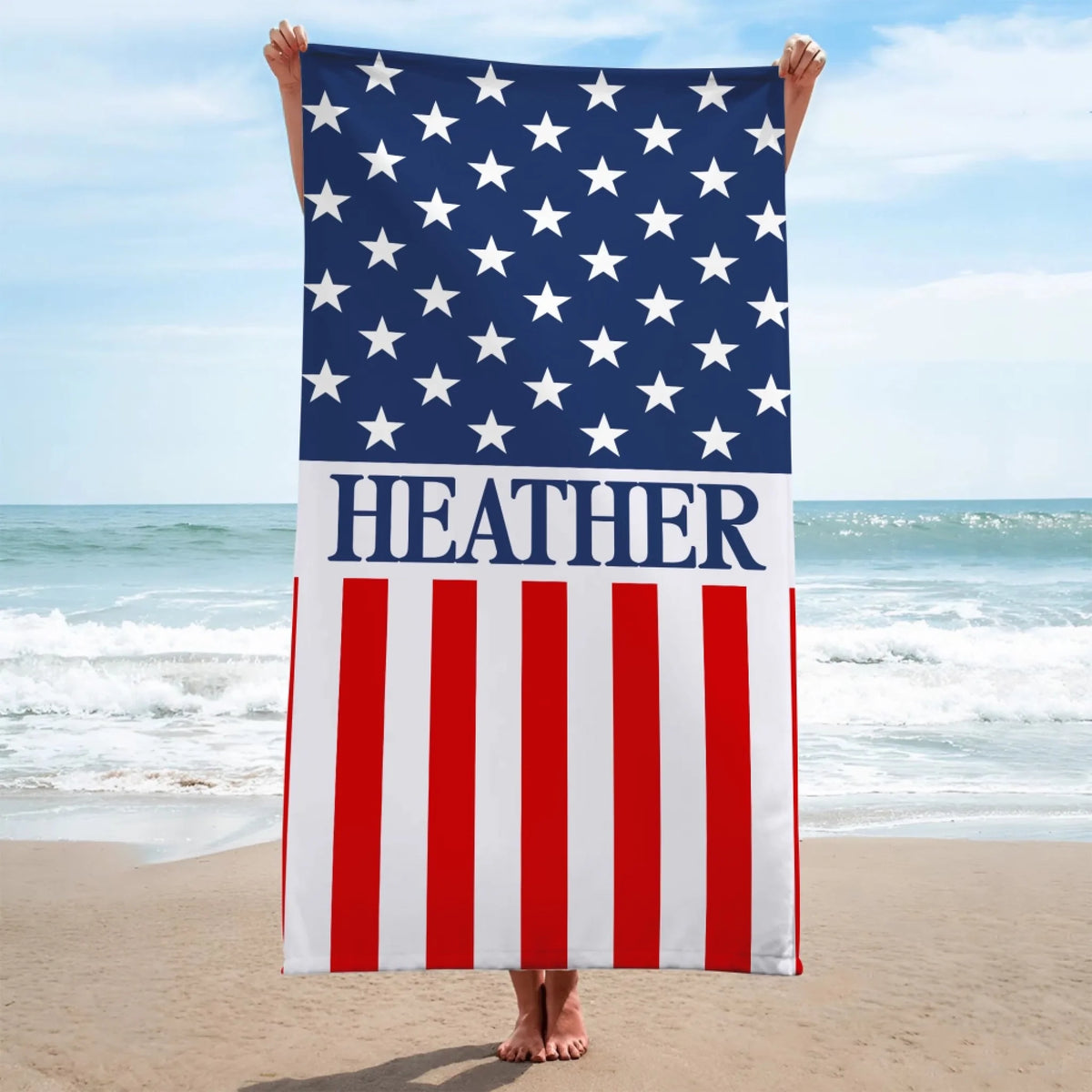 Person holding up a vertical American flag beach towel personalized with the name Heather for Independence Day outings.