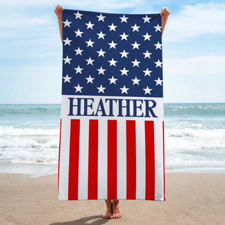 Person holding up a vertical American flag beach towel personalized with the name Heather for Independence Day outings.