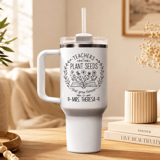 White personalized teacher tumbler featuring Teachers Plant Seeds design displayed on a wooden desk for teachers.
