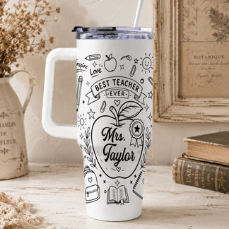 A white insulated tumbler for teachers, featuring black drawings of pencils, books, and an apple with custom name text.