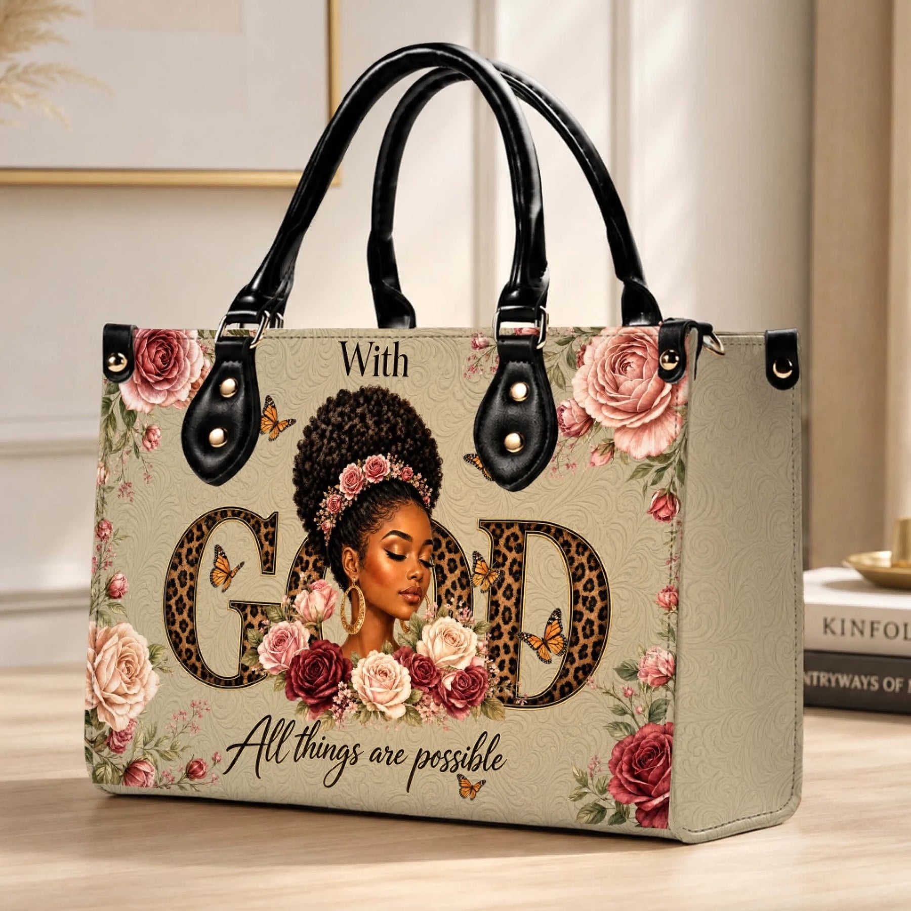 Beige tote bag with black handles, artistic illustration of a black woman, roses, butterflies, and faith-based quote.