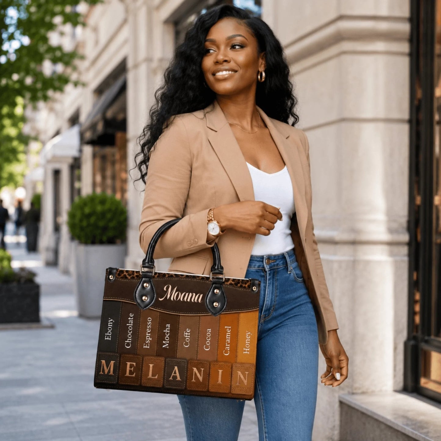 Fashionable woman carrying a stylish personalized handbag with a melanin skin tone gradient print in an urban setting.