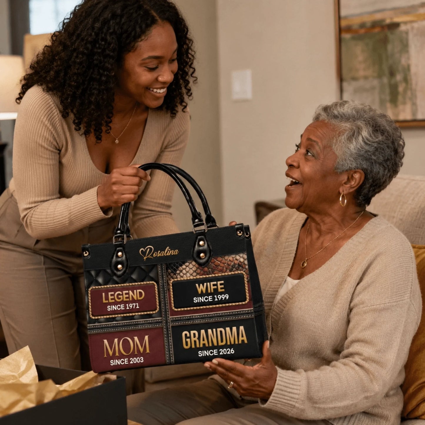 Young woman gifting a personalized leather handbag with family titles and years to an elderly woman for a special celebration.