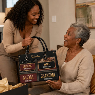 Young woman gifting a personalized leather handbag with family titles and years to an elderly woman for a special celebration.