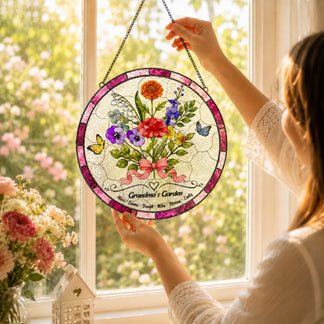 Woman hanging Grandma personalized glass suncatcher with flowers and grandkids names in bright garden window