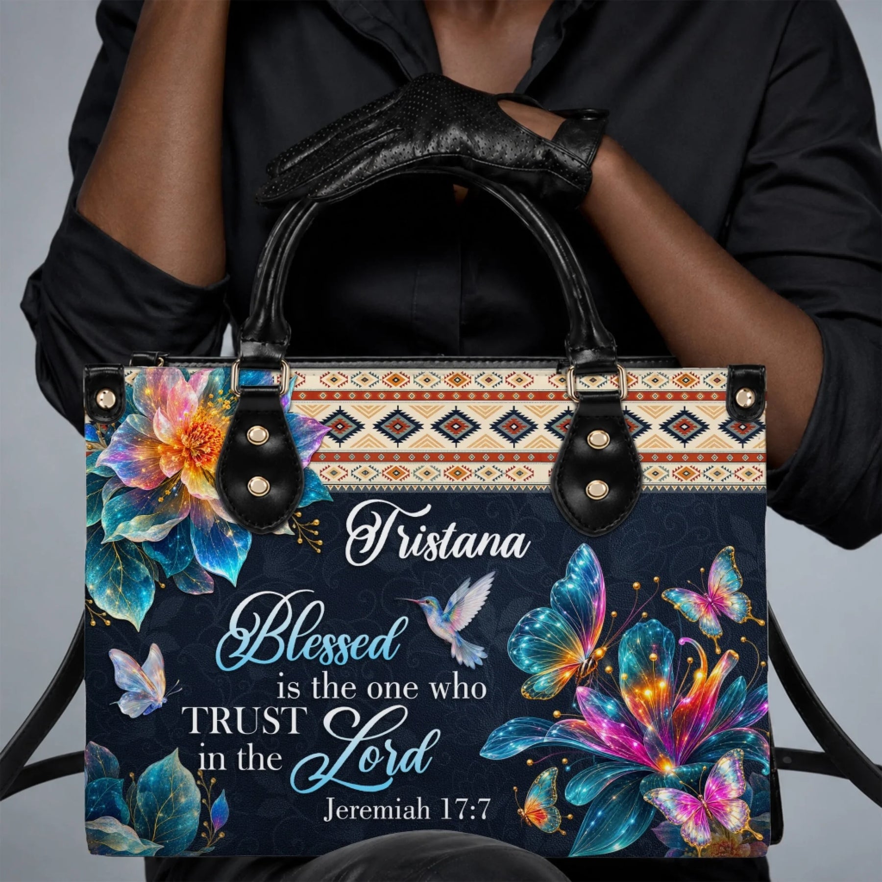 Person holding a custom handbag with butterfly and hummingbird design featuring religious quote and name Tristana