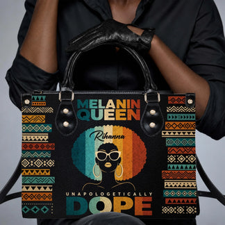 A woman holding a personalized Melanin Queen handbag with vintage style afro art and bold text, perfect for daily use.