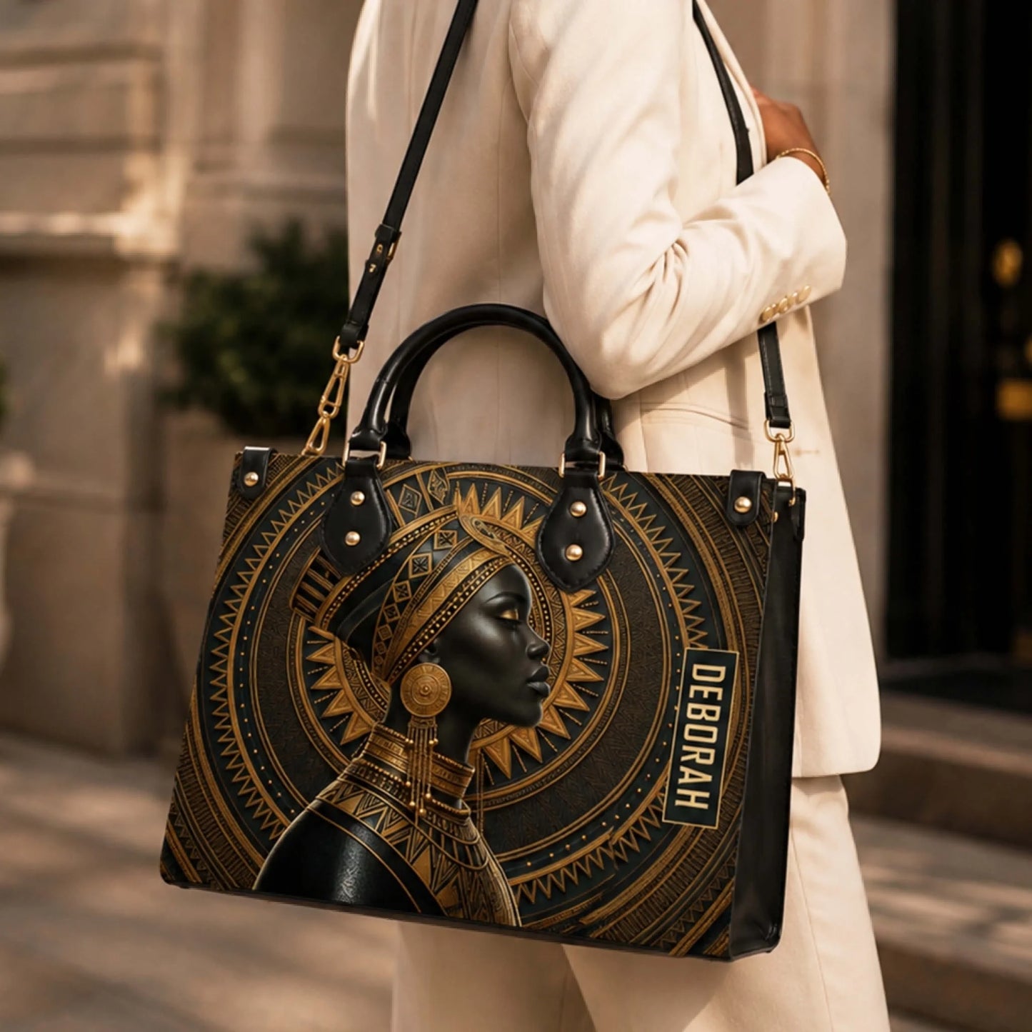 Stylish woman wearing a blazer carrying a personalized African queen themed handbag with the custom name Deborah.