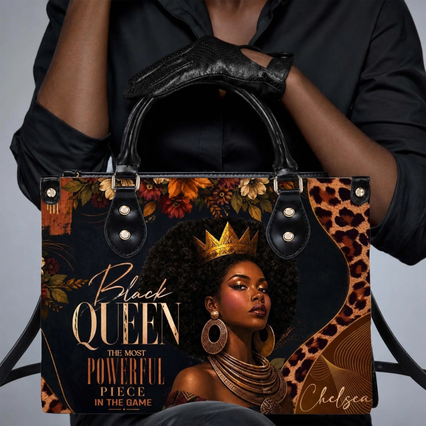 A person holding a custom Black Queen tote bag with elegant artwork of a crowned woman and golden accent text.