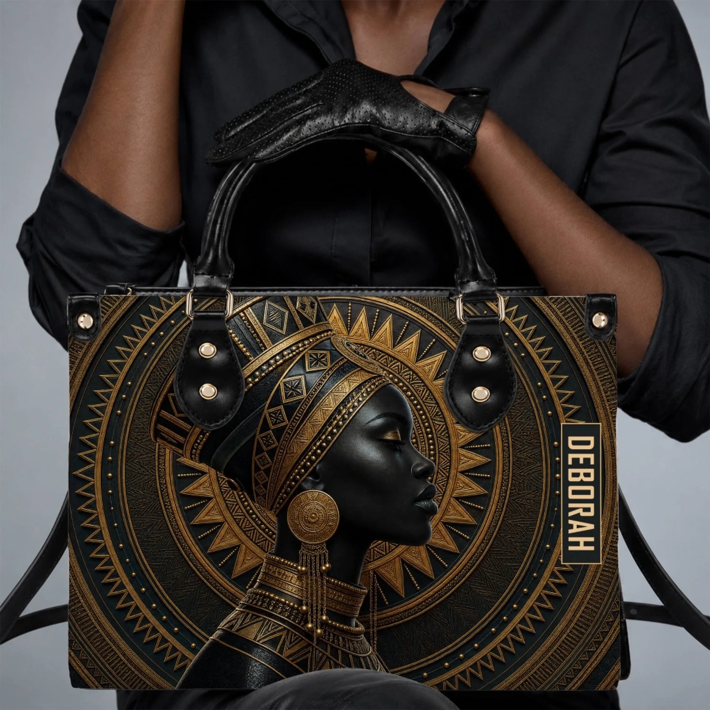 A woman wearing black clothes holding a stylish personalized tote bag with a striking African queen graphic art.