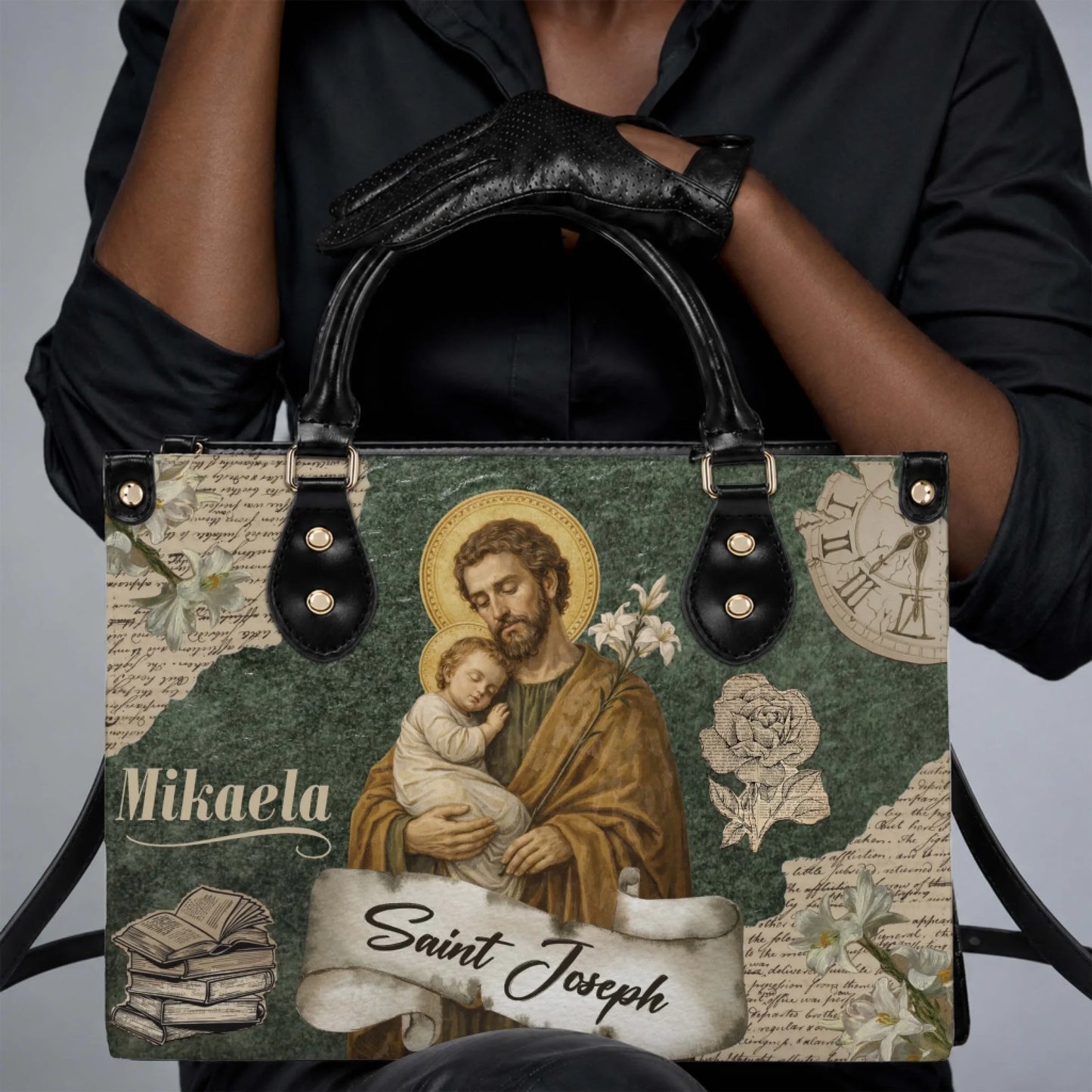 A woman holding a custom Mikaela Saint Joseph religious print handbag with black leather handles and trim.