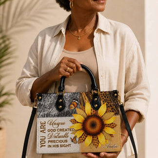 A woman holding a stylish personalized sunflower and butterfly tote bag featuring the name Amelia and inspirational text.
