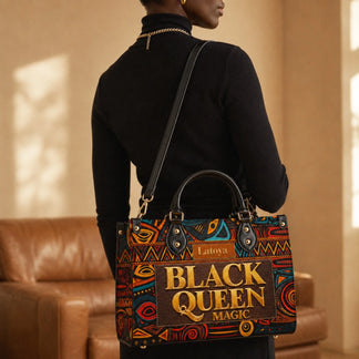 A woman carrying a custom personalized Black Queen Magic handbag with a bold and colorful African-inspired art pattern.